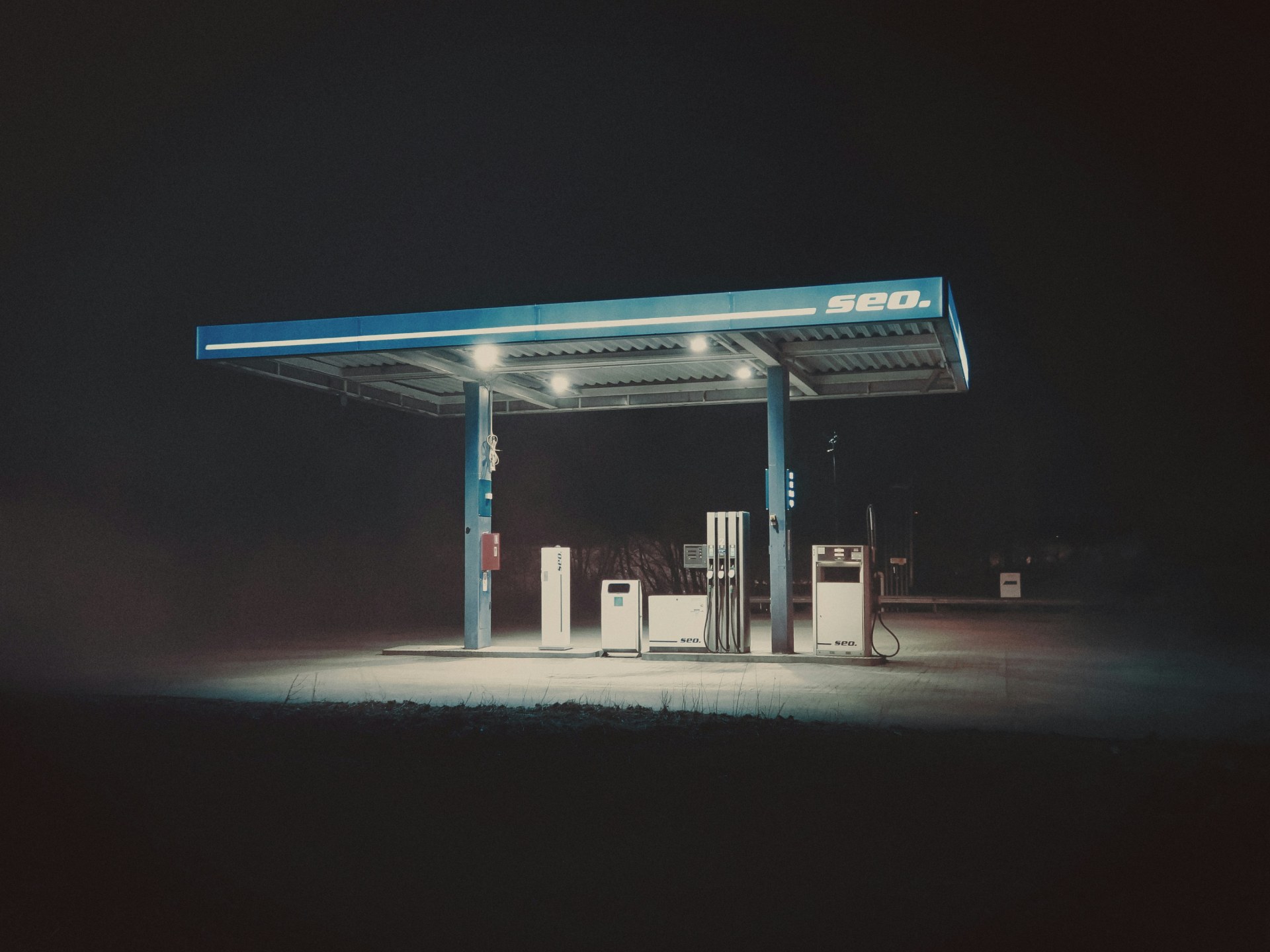 Isolated gas station illuminated in darkness